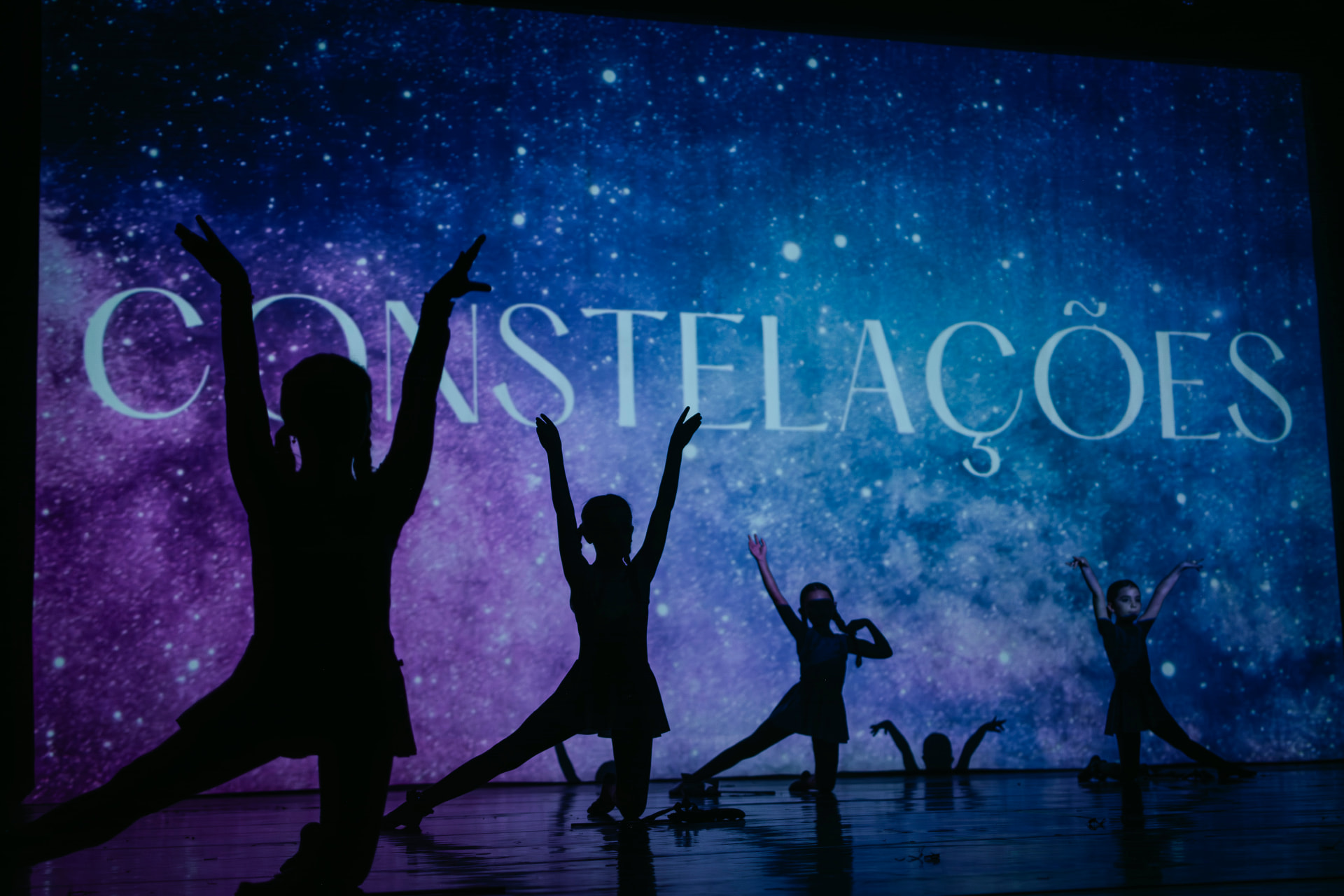 Ginastas da Atria em movimento sob a iluminação do palco